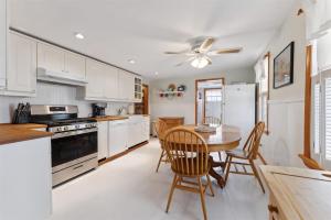a kitchen with white cabinets and a table and chairs at 234 W 1St Ave in North Wildwood