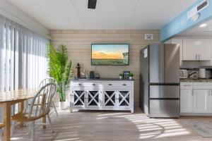 a kitchen with a stainless steel refrigerator and a table at 301 Ocean Ave, Unit 102 - The Harbor Light in North Wildwood