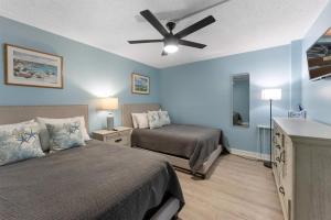 a bedroom with two beds and a ceiling fan at 301 Ocean Ave, Unit 102 - The Harbor Light in North Wildwood +12 photos
