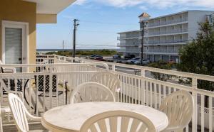 un tavolo bianco e sedie su un balcone con un edificio di 411 E Morning Glory Rd, Unit 2003 a Wildwood
