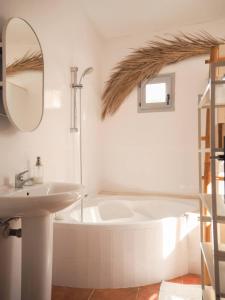 a bathroom with a sink and a tub and a mirror at Casa Augustin, village house in Mojacar Pueblo in Mojácar