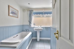 une salle de bain avec une baignoire et un lavabo dans l'établissement Riverview Cottage - North East Escapes, à Warkworth 21 autres photos