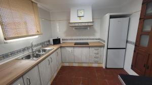 a small kitchen with a sink and a refrigerator at Buenavista in Ayamonte