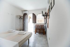 a bedroom with a bed and a dining room at Il Villaggio Del Mago in Lampedusa