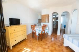 a living room with a table and chairs and a television at Il Villaggio Del Mago in Lampedusa