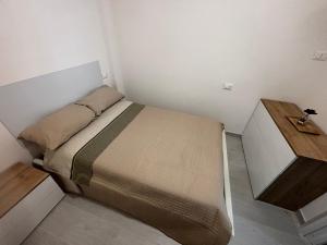 ein kleines Schlafzimmer mit einem Bett und einem Holzschreibtisch in der Unterkunft Brezza Marina in Montesilvano