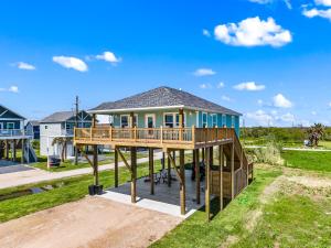 a house with a large deck on the grass at Gorgeous 4BD with Hot Tub, Golf Cart, Deck, Gourmet Kitchen in Gilchrist
