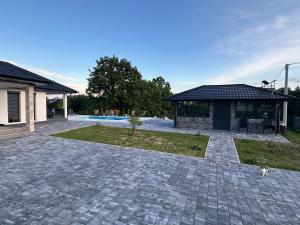 Un camino de entrada de ladrillo con un pabellón y una casa. en Art Residence, en Tuzla 21 fotos más