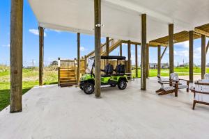 a green golf cart parked under a pavilion at Gorgeous 4BD with Hot Tub, Golf Cart, Deck, Gourmet Kitchen in Gilchrist