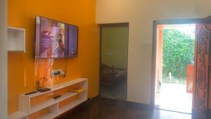 a living room with a flat screen tv on a wall at Royal Peters Holiday Homes, Main Falls, Coutralam in Kuttālam