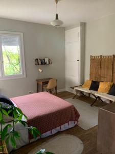 a bedroom with a bed and a desk and a window at La villa du Moulin in Aujac