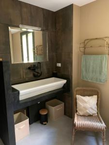 a bathroom with a sink and a mirror and a chair at La villa du Moulin in Aujac +40 photos