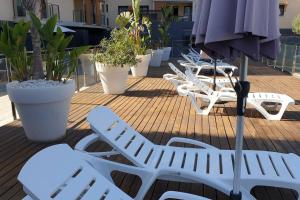 a row of white lounge chairs on a deck at Apartamento de Lujo Cerca de la Playa EL CAMPELLO in El Campello +42 photos