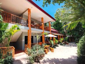 a building with a balcony with people sitting on it at Maria's Inn Deluxe Room in Pooc +3 photos