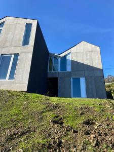 a house on top of a grassy hill at UMI surf yoga house Doniños beach in Ferrol