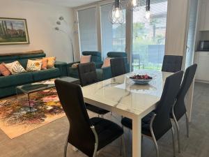 a dining room with a white table and chairs at LabPark design Melano in Melano