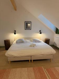 a bedroom with a large white bed with two pillows at Les chambres du parc du Château in La Ferté-Saint-Aubin