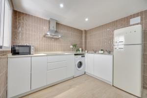 a kitchen with white cabinets and a washer and dryer at La Pequeña Gran Casa by Clabao in Viana