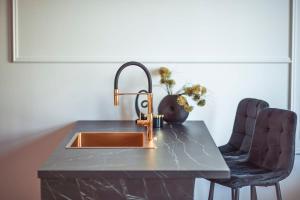 クフィジンにあるApartament Glamourの- キッチンカウンター(シンク、椅子2脚付) +2枚の写真