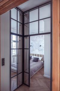 クフィジンにあるApartament Glamourのベッドルーム1室(ベッドにつながる大きなガラスドア付)