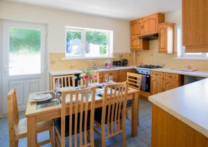 a kitchen with a wooden table and chairs in it at Cozy 3 bed family home by park in Penrith