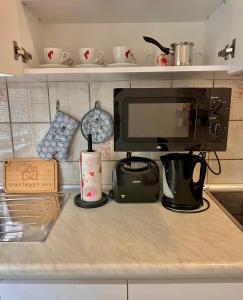 a kitchen counter with a coffee maker and a microwave at Apartment Rea Ilidža 2 in Sarajevo