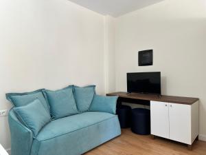 a living room with a blue couch and a television at Eval Hotel in Sarandë