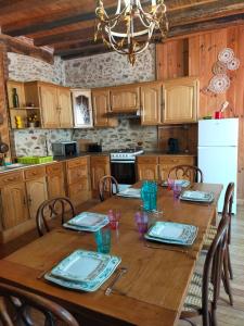 a kitchen with a wooden table with chairs and a chandelier at maison médiéval pour six personnes in Saint-Benoît-du-Sault
