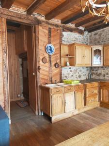 a kitchen with wooden cabinets and a clock on the wall at maison médiéval pour six personnes in Saint-Benoît-du-Sault