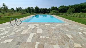 a swimming pool on a patio with a stone floor at Agriturismo La Taverna in Sovicille