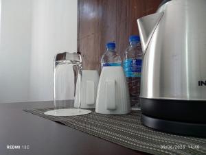 a counter with a coffee maker and bottles of water at Homestay with AC Wi-Fi and Hot Water near Colombo in Peliyagoda