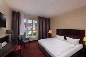 a hotel room with a bed and a desk and a window at SORAT Hotel Cottbus in Cottbus +61 photos