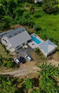 an overhead view of a house with a pool and cars at Bungalow au Coeur du Vert RO 4 in Sainte-Anne