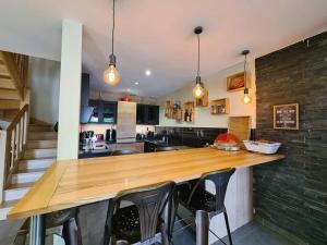 a kitchen with a wooden counter and some chairs at Maison familiale à la campagne in Alby