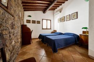 a bedroom with two beds and a stone wall at Poggio Diavolino - Suvereto in Suvereto