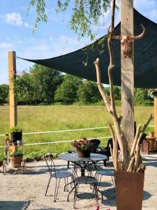 a table and chairs and a table with a tree at Gîte "La belle vie" in Chamblet