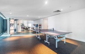 una habitación con mesa de ping pong en un gimnasio en Impressive City Skyline w Pool Gym & Sauna, en Melbourne