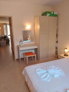 a bedroom with a bed and a desk and a cabinet at 2 Room Apartment with Poolview Royal Sun in Sunny Beach