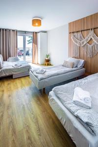 a bedroom with three beds in a room at Mazurskie Apartamenty "Jak Tu Miło!" in Węgorzewo +24 photos