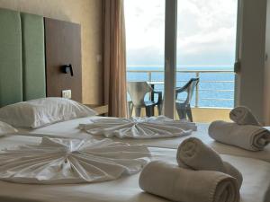 two beds in a hotel room with a view of the ocean at Eval Hotel in Sarandë +72 photos