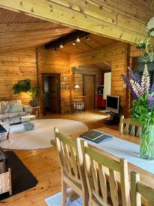 a large living room with a table and chairs at Blockhütte in Alleinlage in Ulricehamn