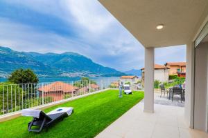 a patio with a view of the water and mountains at Spa Stella Lario in Lezzeno