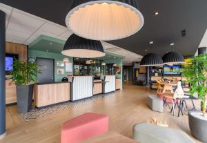 a restaurant with tables and chairs and potted plants at B&B HOTEL Compiègne in Compiègne