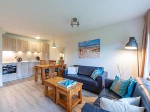 a living room with a couch and a table at Beach Apartment 7 for 4 guests in Callanstoog in Callantsoog +13 photos