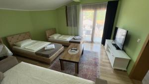 a living room with two beds and a tv at Prizren Apartment's in Prizren +68 photos