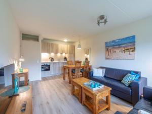a living room with a blue couch and a table at Beach Apartment 7 for 4 guests in Callanstoog in Callantsoog