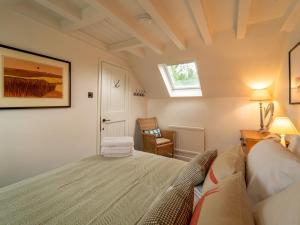 a bedroom with a bed and a window and a chair at The Old Reading Room Peaceful Village Retreat Pass the Keys in Wigginton