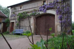 a building with a wooden gate and a blue bench at Gite Mentrel in Champ-le-Duc +12 photos