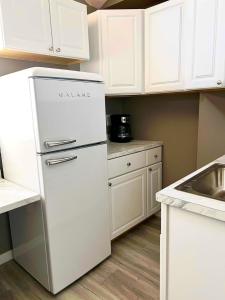 una nevera blanca en una cocina con armarios blancos en Nanas Lil House, en Maryville 5 fotos más