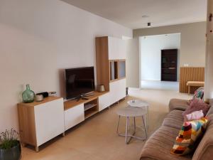 a living room with a couch and a flat screen tv at B&B Ut Zuuje in Valkenburg